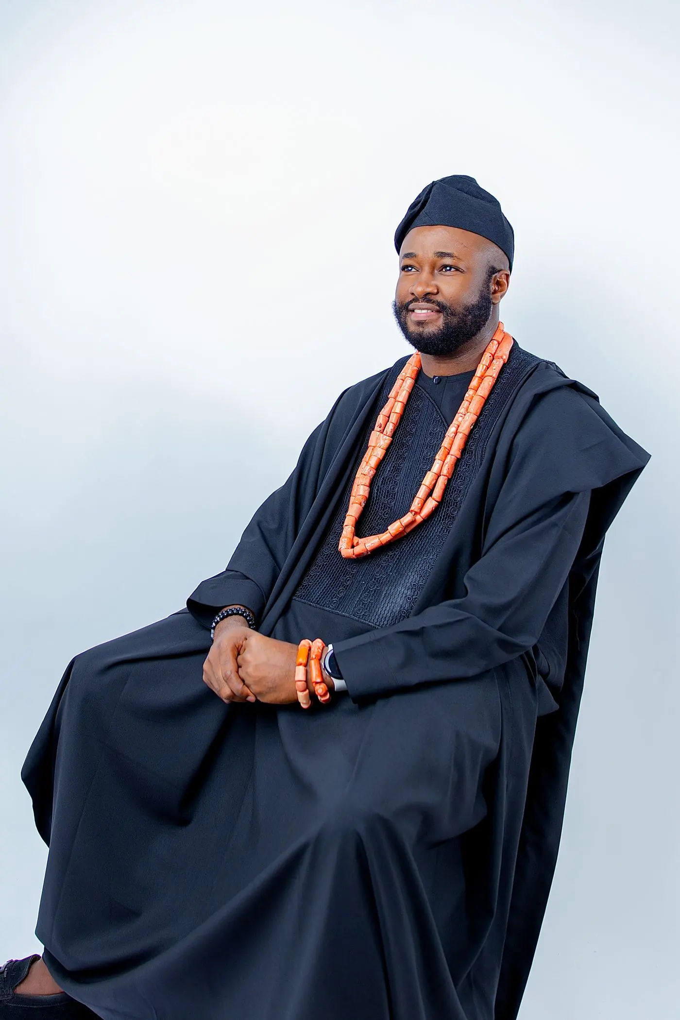 Studio portrait in Calgary: man in a black agbada with coral beads