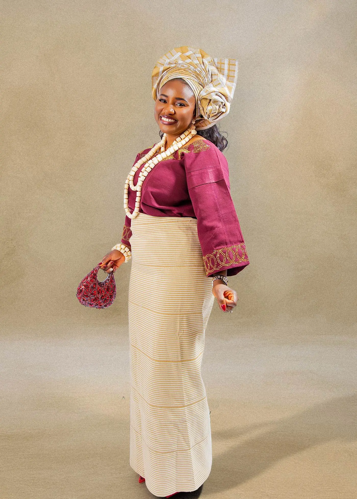Traditional Nigerian wedding attire photographed in Calgary: gele head tie, aso-oke wrapper and coral beads